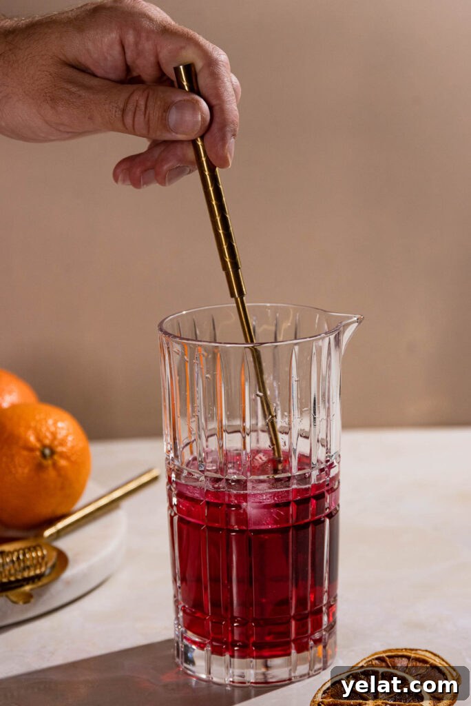 Hand stirring cocktail in a cocktail shaker. 