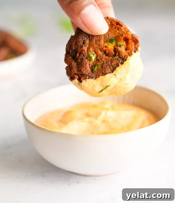 A crispy black-eyed pea patty dipped into Cajun sauce
