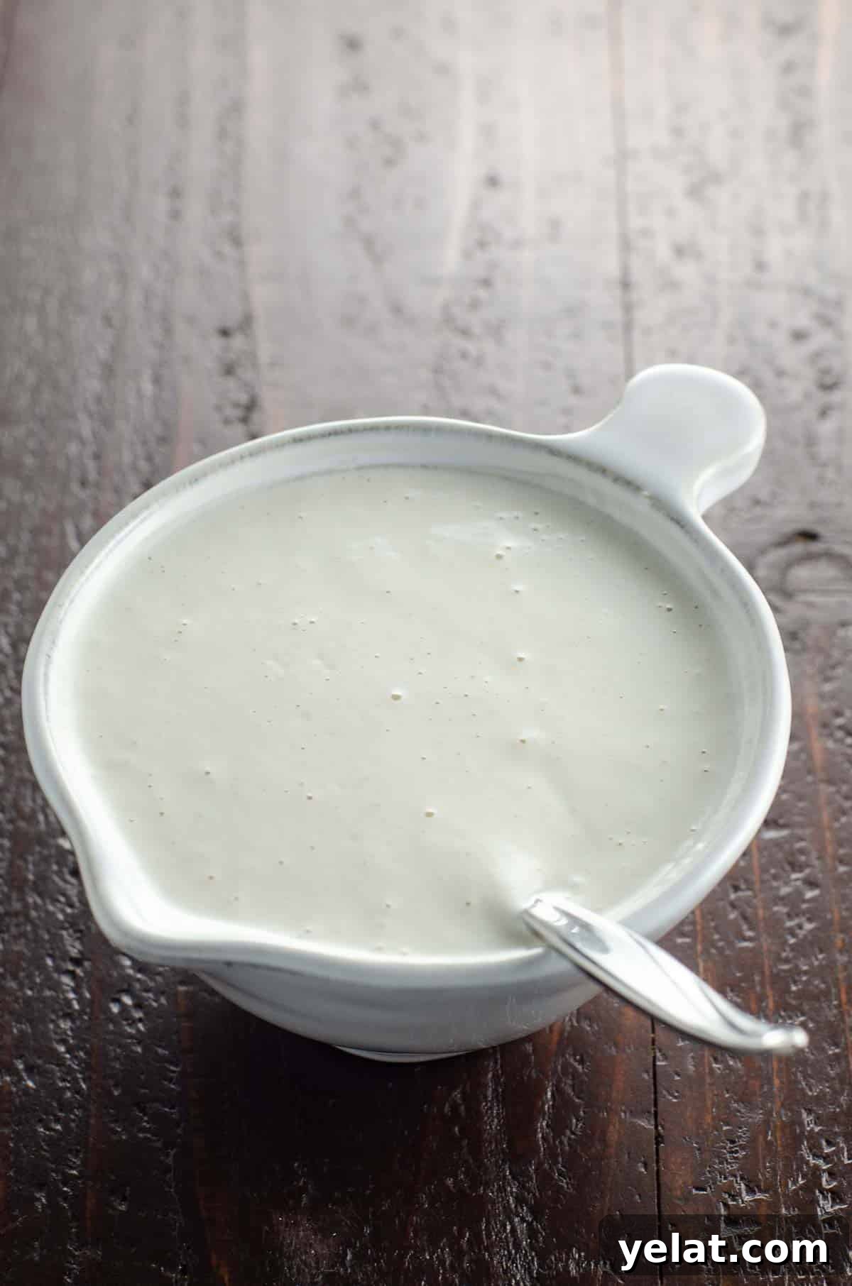 vegan cashew cream in a small pitcher with a spoon