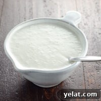 vegan cashew cream in a small pitcher with a spoon