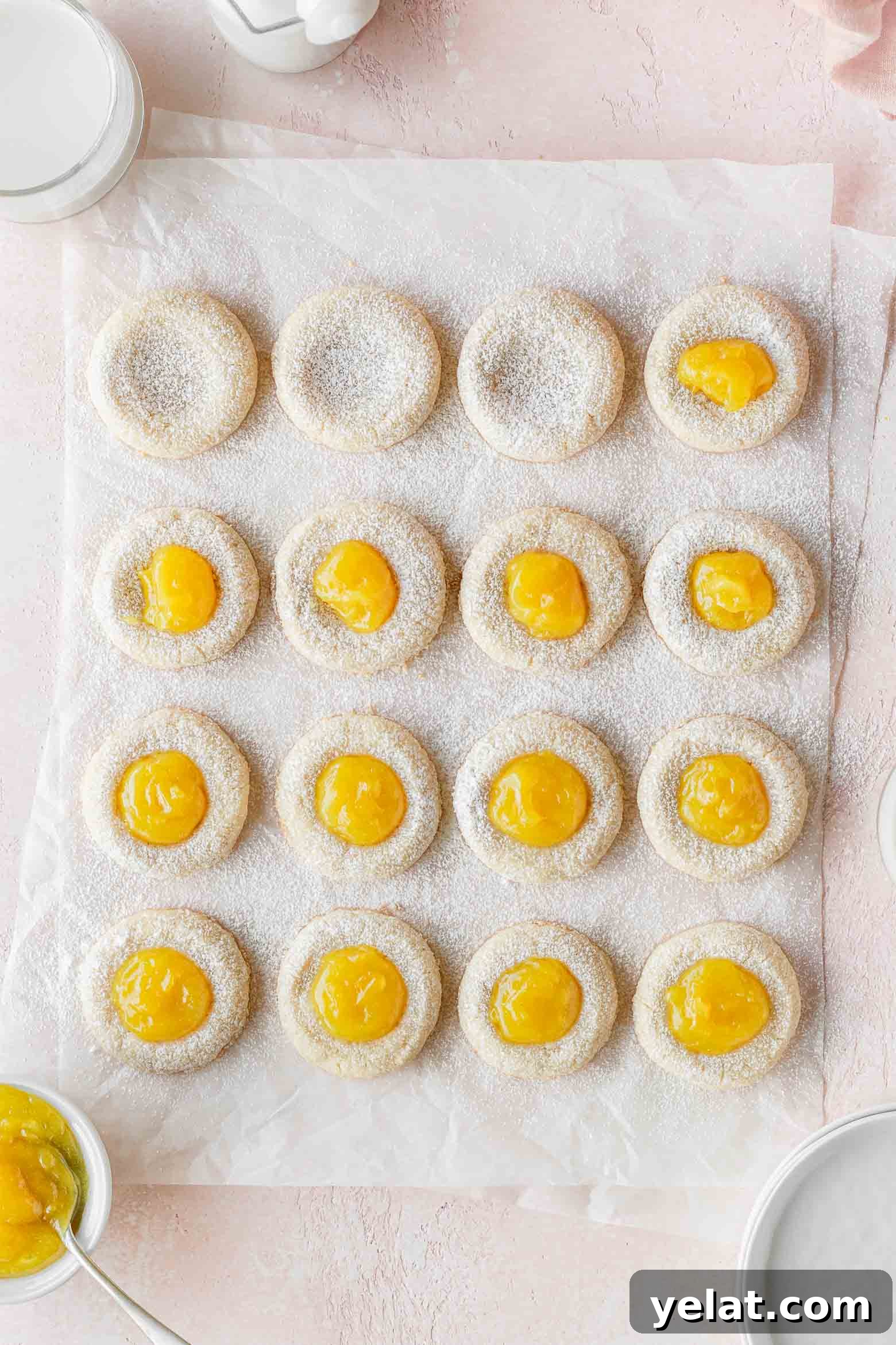Lemon Curd Thumbprint Cookies — Zesty Homemade Cookie Recipe 8 Lemon thumbprint cookies being filled with lemon curd.
