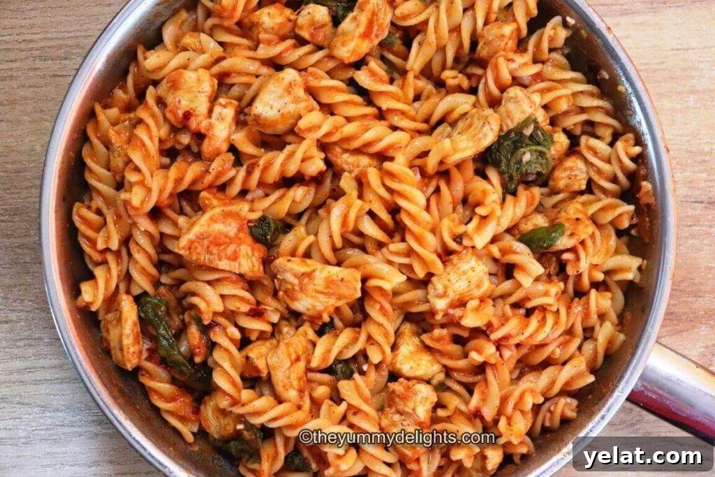 Creamy Tomato Spinach Chicken Pasta Recipe 3 top view of tomato spinach chicken pasta dish in the skillet.