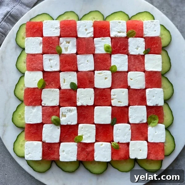 Fresh Watermelon Salsa Recipe for Summer Parties 5 A square salad arranged like a checkerboard with alternating cubes of watermelon and feta, garnished with small basil leaves, and surrounded by overlapping cucumber slices on a round white plate—perfect for fresh, healthy bites.