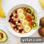 Healthy Nutella smoothie bowl with banana and avocado topped with banana, kiwi fruit, dried apricots, cranberries and hazelnuts