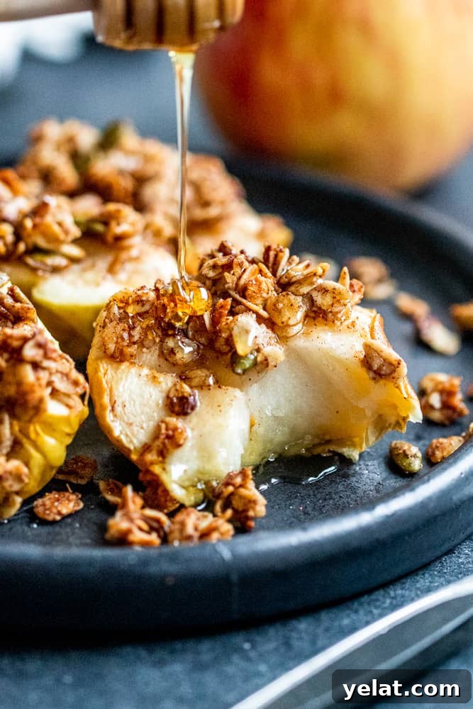 Crispy Air Fryer Apples with Honey Oat Crumble 6 Apple with bite out of it and honey being drizzled over.