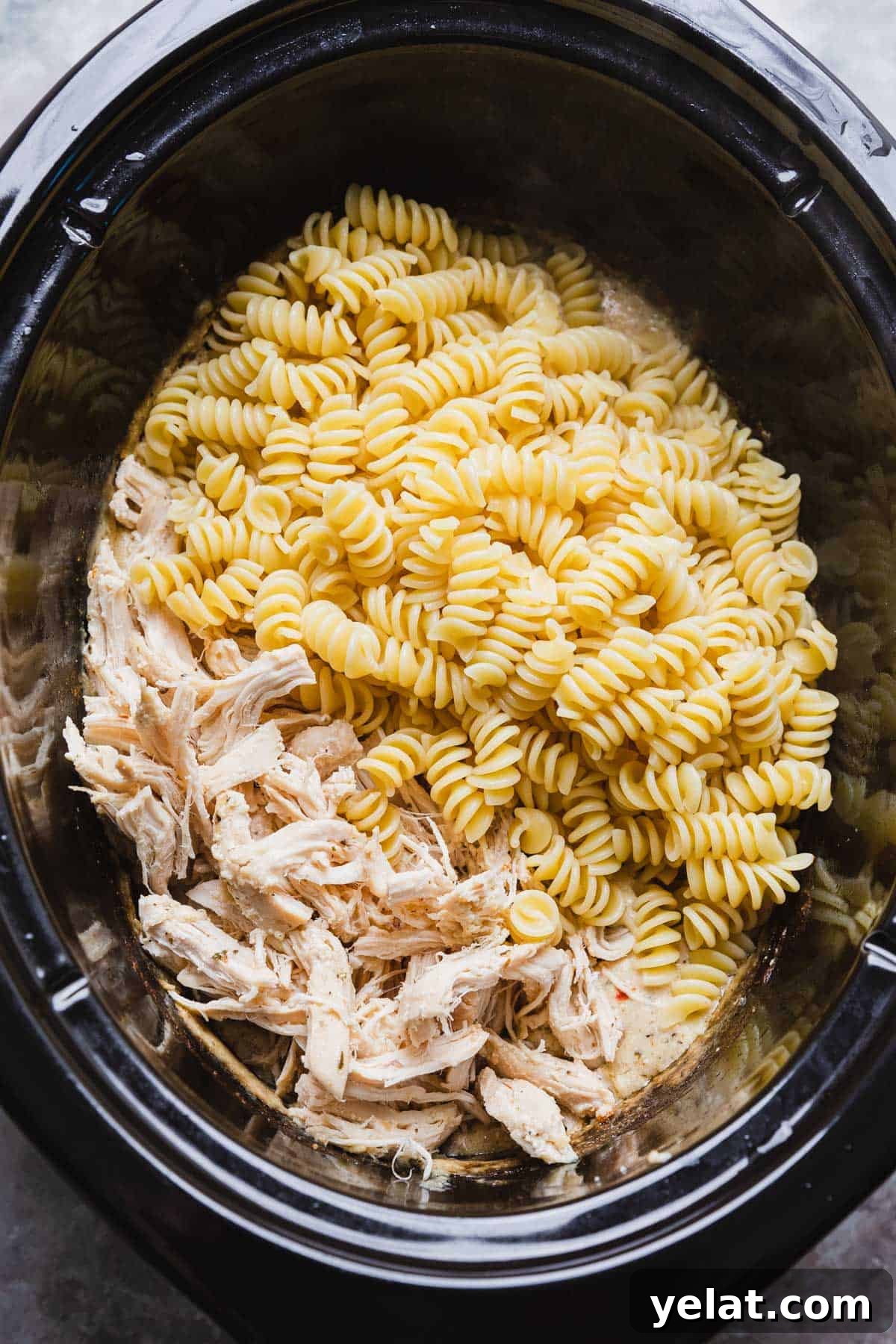 Slow-Cooker Garlic Parmesan Chicken Pasta Recipe 9 cooked pasta added to a crockpot with shredded chicken