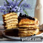 25 Sourdough Breakfast Ideas: 25+ Recipes for Morning Bread Dishes 3 A plate with a stack of sourdough discard pancakes with a slice of them taken out.