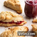 25 Sourdough Breakfast Ideas: 25+ Recipes for Morning Bread Dishes 6 Scones with a jar of raspberry jam and one scone with jam inside.