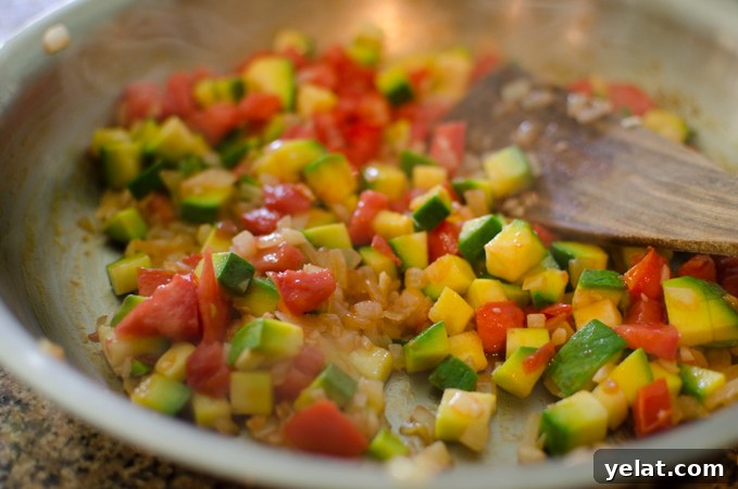 Tomato, Egg & Tofu Stir-Fry: Quick Savory Weeknight Recipe 5 Zucchini and tomato pieces are added to onion and cooked.