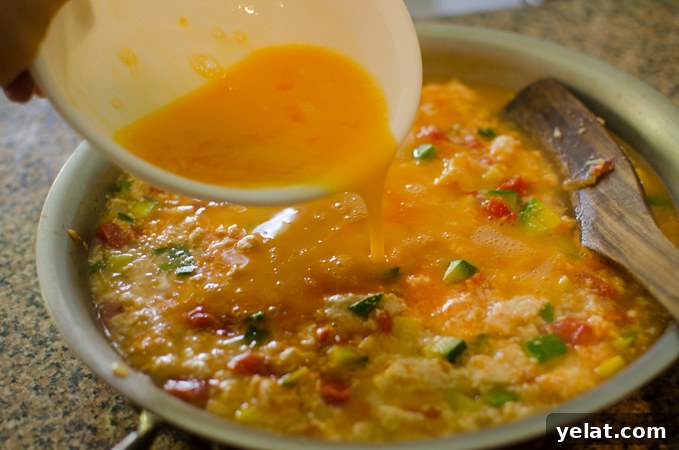 Tomato, Egg & Tofu Stir-Fry: Quick Savory Weeknight Recipe 7 Beaten eggs are added to soft tofu and vegetables in a pan.