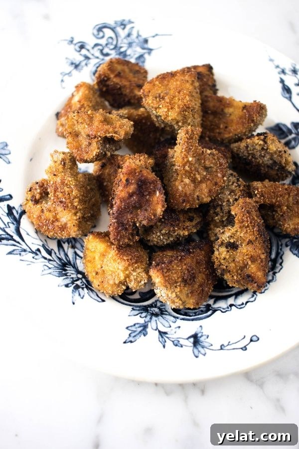 Crispy Oven-Baked Breaded Mushrooms with Light Coating 2 Breaded Mushrooms on a blue and white plate