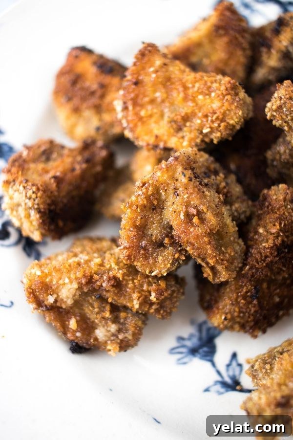 Crispy Oven-Baked Breaded Mushrooms with Light Coating 3 Breaded Mushrooms on a blue and white plate