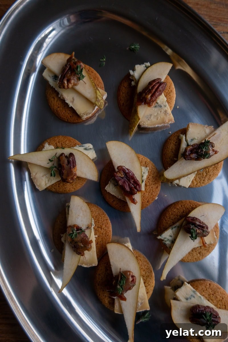 Ginger biscuits topped with slices of stilton and pear, garnished with candied pecans - Georgie Mullen