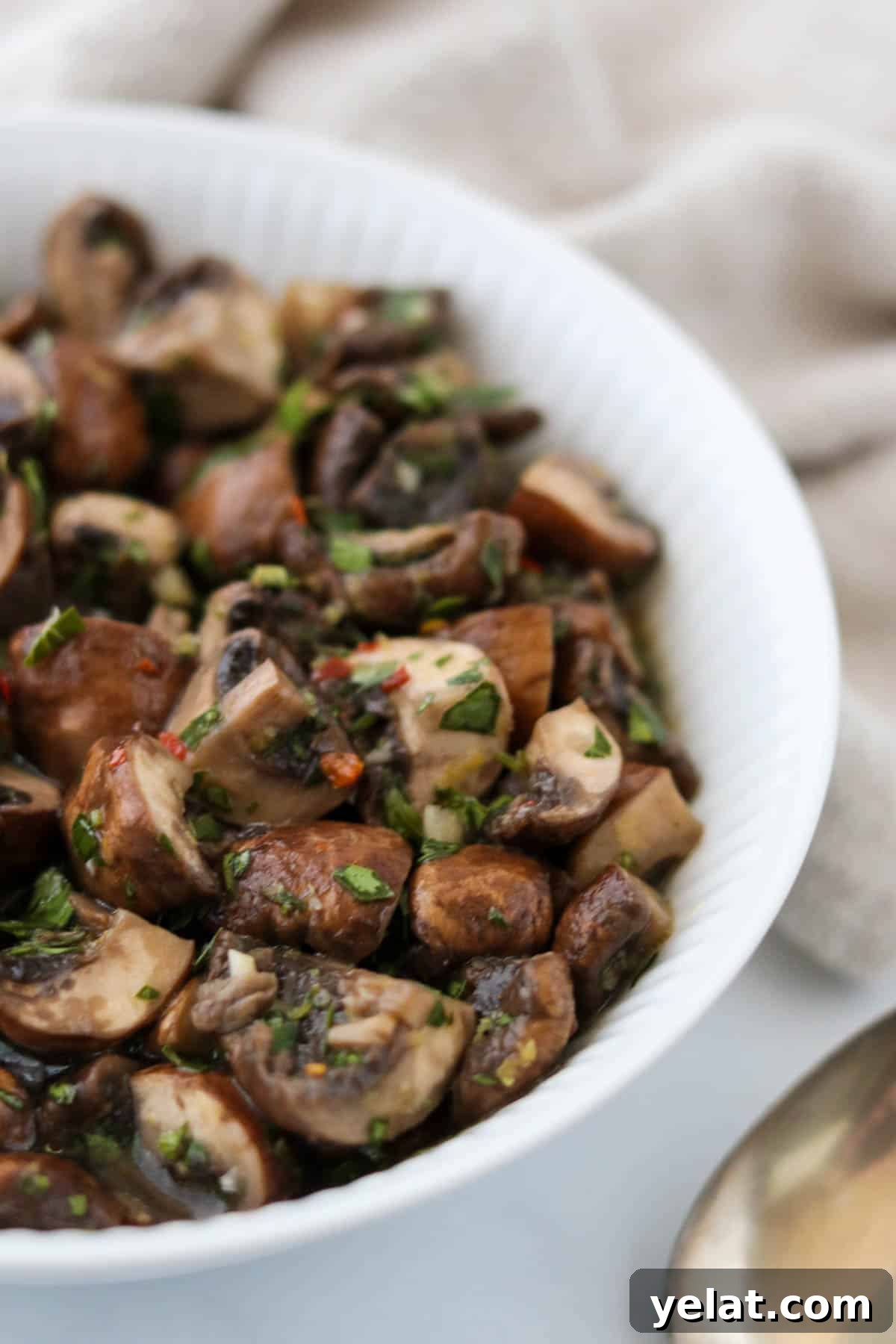 Quick Pickled Mushrooms: Fast Tangy Recipe for Snacks and Sides 2 Quick pickled mushrooms in a bowl next to a spoon.