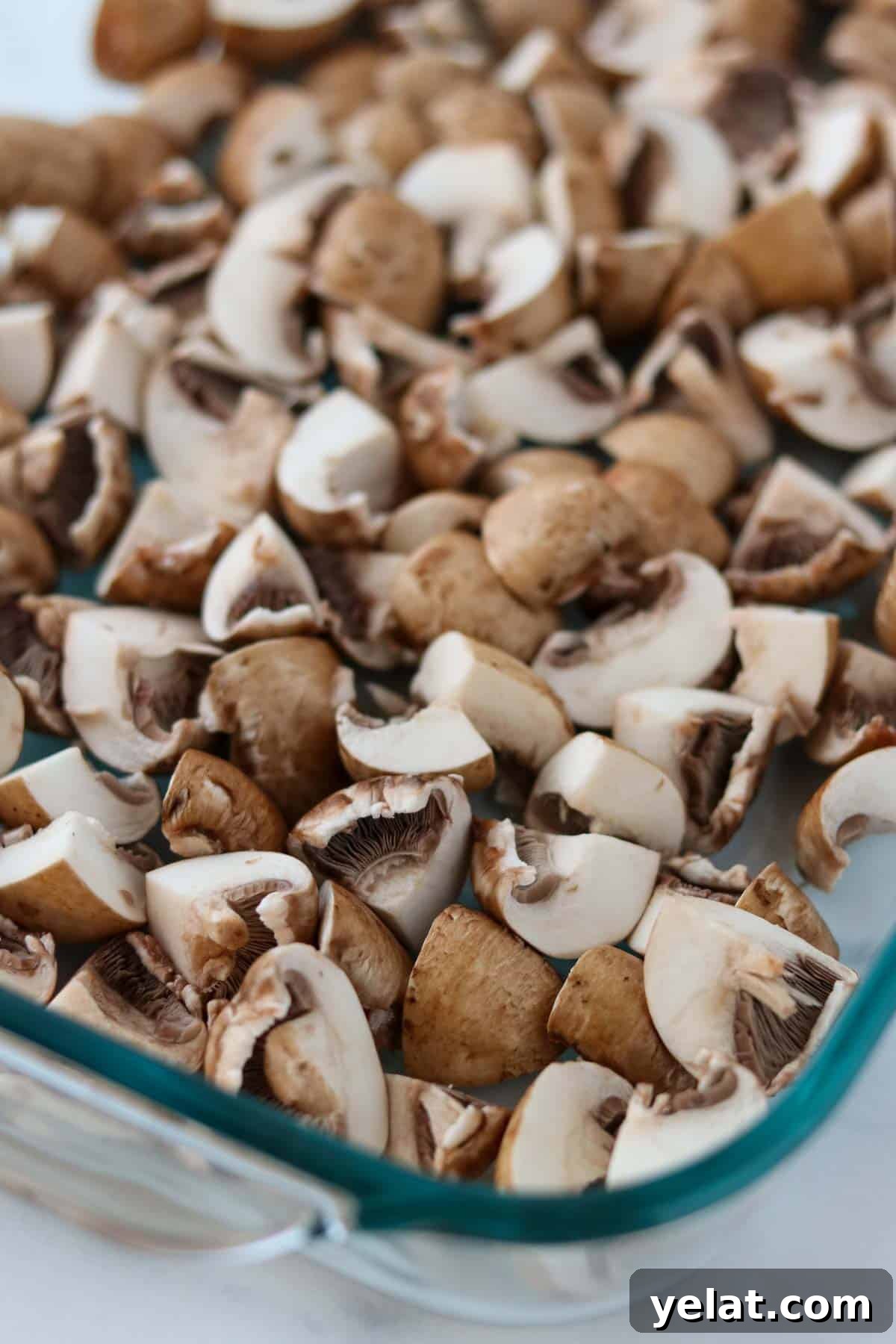 Quick Pickled Mushrooms: Fast Tangy Recipe for Snacks and Sides 4 Raw quartered mushrooms in a glass baking dish.